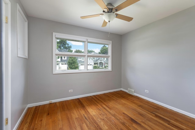 spare room featuring wood finished floors, baseboards, and ceiling fan