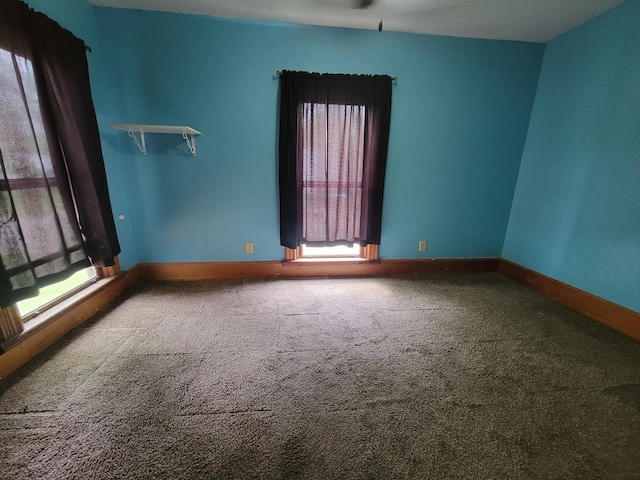 carpeted spare room with baseboards
