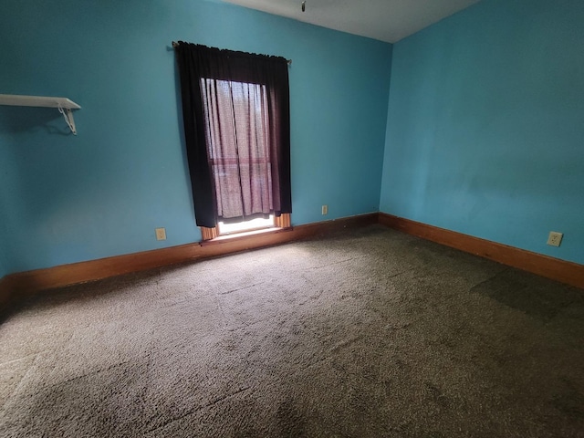 carpeted spare room with baseboards