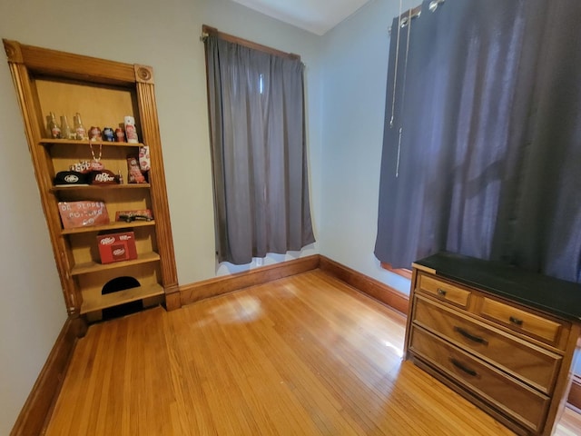 bedroom with baseboards and wood finished floors