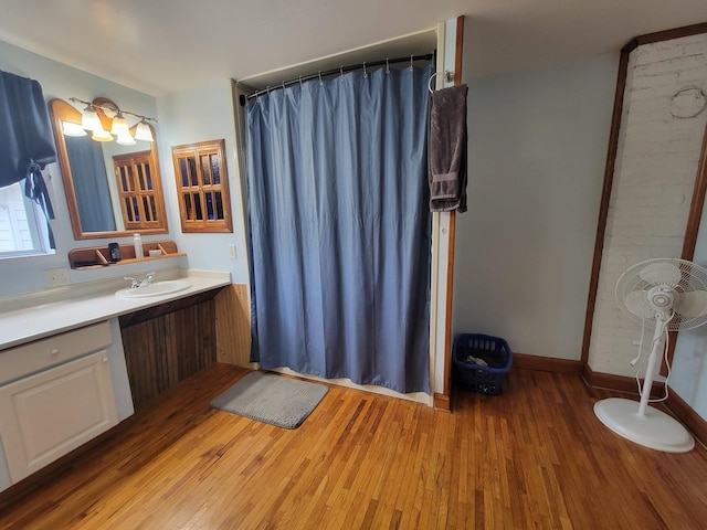 bathroom with vanity, curtained shower, baseboards, and wood finished floors