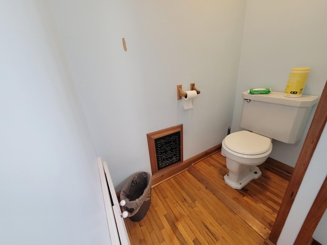 bathroom featuring toilet, baseboards, hardwood / wood-style floors, and visible vents