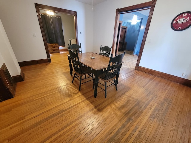 dining area featuring light wood-style flooring, radiator, and baseboards