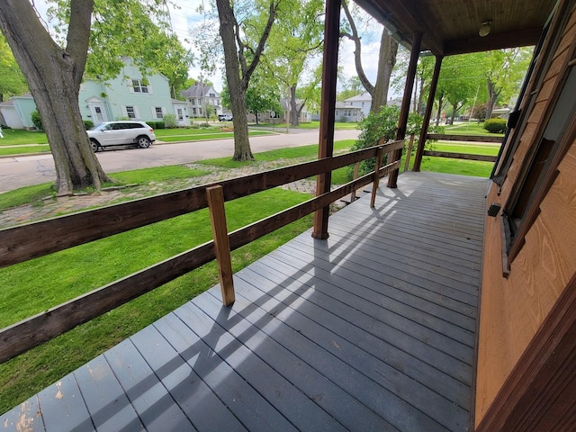 deck featuring a porch, a yard, and a residential view