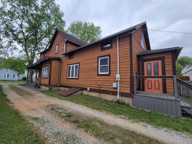 view of property exterior with dirt driveway