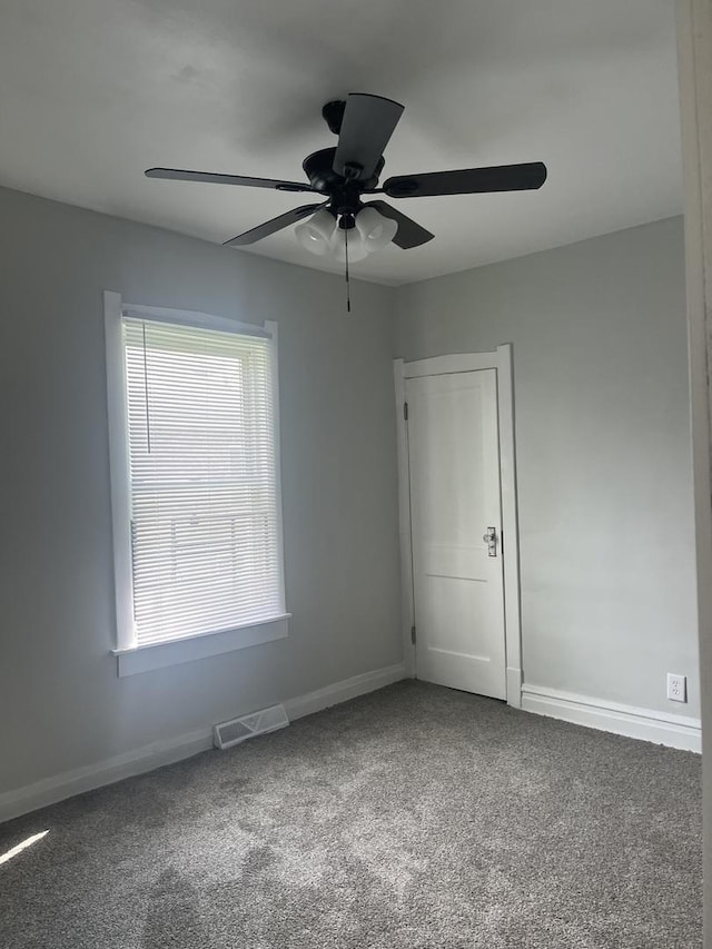 spare room featuring a ceiling fan, carpet flooring, visible vents, and baseboards