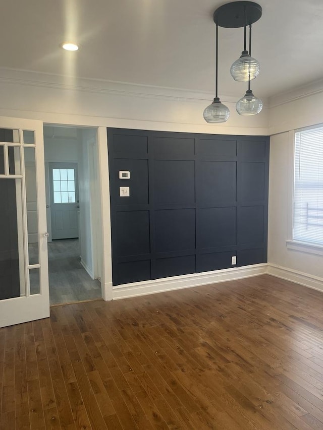 interior space featuring baseboards, ornamental molding, and dark wood finished floors