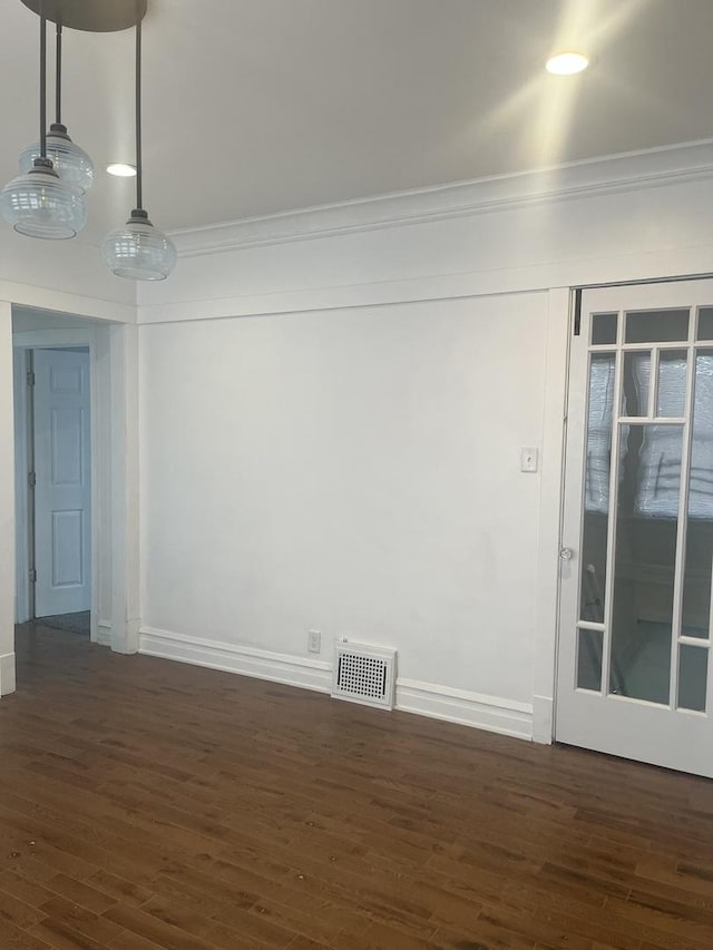 spare room with baseboards, crown molding, visible vents, and dark wood-type flooring