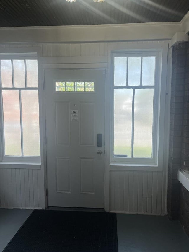 foyer entrance with a wealth of natural light and concrete flooring