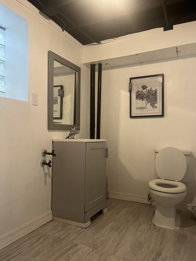 bathroom with vanity, toilet, baseboards, and wood finished floors