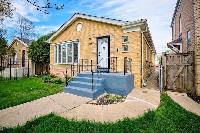 bungalow-style home featuring a front lawn, brick siding, a gate, and fence