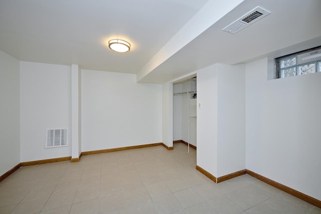basement with baseboards and visible vents