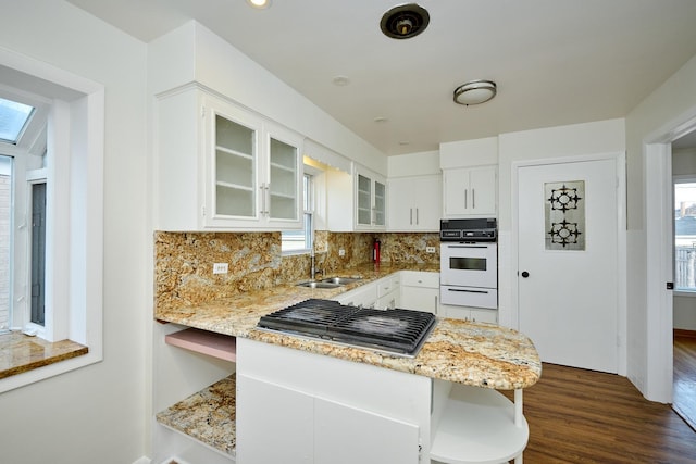 kitchen featuring stainless steel gas cooktop, oven, light stone counters, and a warming drawer
