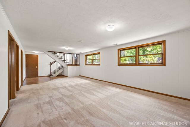 6540 Terrace Dr, Downers Grove, IL 60516 - below grade area featuring stairway, light colored carpet, a textured ceiling, and baseboards