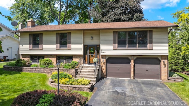 6540 Terrace Dr, Downers Grove, IL 60516 - raised ranch featuring an attached garage, brick siding, driveway, a front lawn, and a chimney