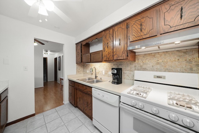 kitchen with under cabinet range hood, white appliances, ceiling fan, a sink, and light countertops