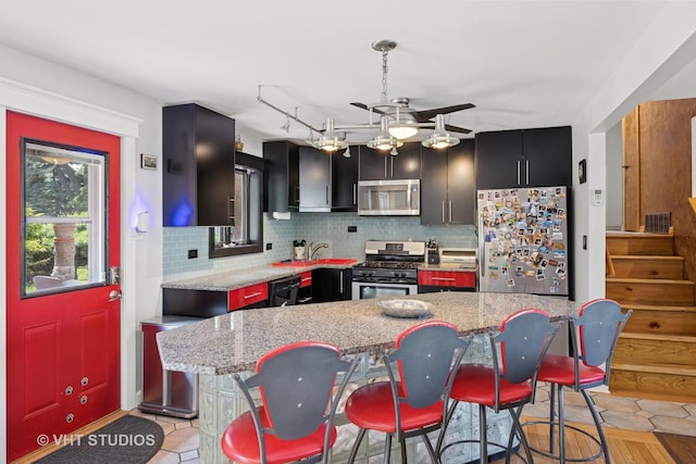 20W315 S Frontage Rd, Lemont, IL 60439 - kitchen featuring stainless steel appliances, dark cabinetry, a ceiling fan, and backsplash