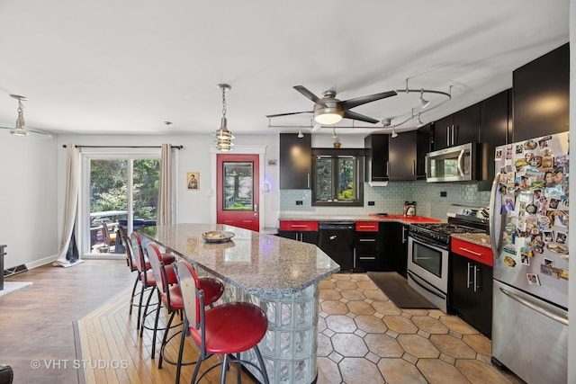 20W315 S Frontage Rd, Lemont, IL 60439 - kitchen featuring appliances with stainless steel finishes, dark cabinetry, a center island, and backsplash