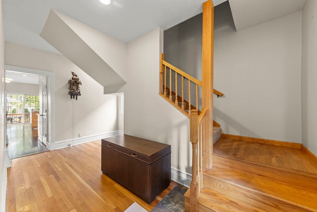 staircase with wood finished floors and baseboards