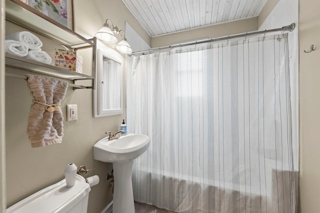 full bathroom with curtained shower, toilet, and a sink