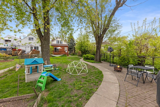 surrounding community featuring an outdoor fire pit, a wooden deck, and a playground