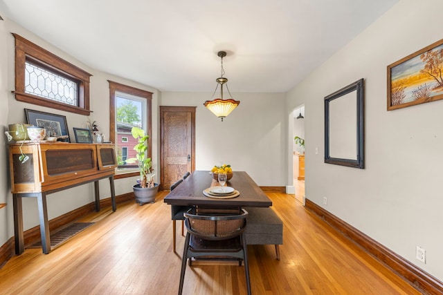 dining room featuring baseboards and light wood finished floors