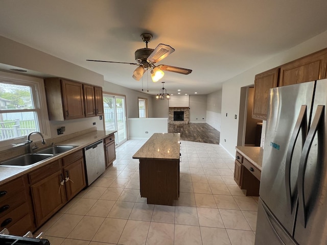 17242 W Rich Ct, Elwood, IL 60421 - kitchen featuring a ceiling fan, a sink, stainless steel appliances, a brick fireplace, and a kitchen island