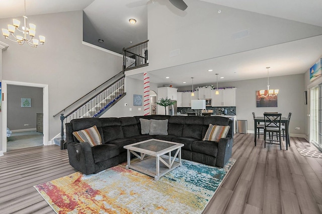11130 Alpine Ln, Orland Park, IL 60467 - living room featuring a chandelier, high vaulted ceiling, light wood-style floors, stairway, and baseboards