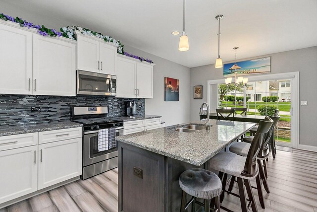 11130 Alpine Ln, Orland Park, IL 60467 - kitchen featuring appliances with stainless steel finishes, a sink, light wood-style floors, and tasteful backsplash