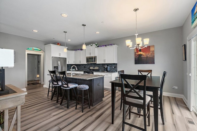 11130 Alpine Ln, Orland Park, IL 60467 - kitchen with appliances with stainless steel finishes, a sink, light wood-style flooring, a chandelier, and backsplash