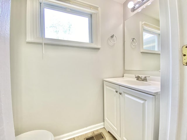 bathroom with vanity, toilet, and baseboards