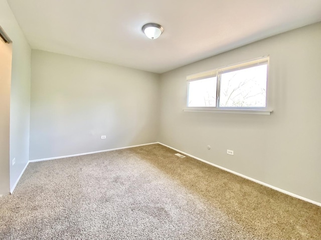 carpeted empty room featuring baseboards