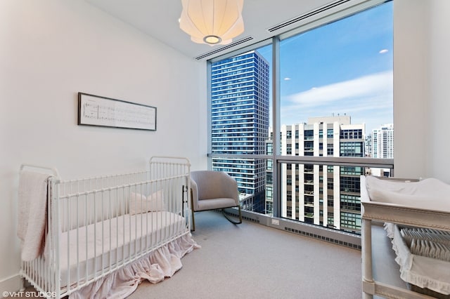 carpeted bedroom with a view of city, floor to ceiling windows, and multiple windows
