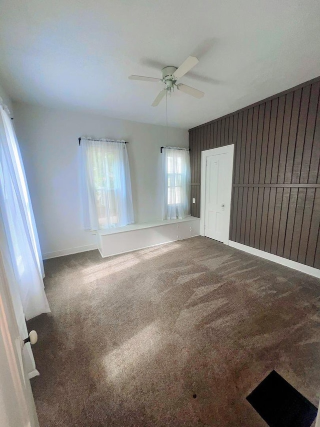 unfurnished room featuring baseboards, carpet, and ceiling fan