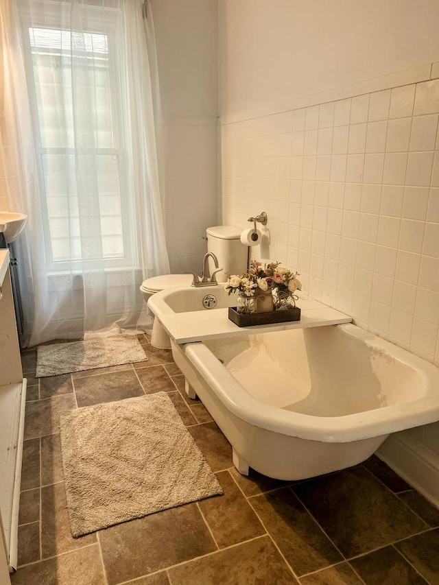 bathroom featuring a freestanding tub and tile walls