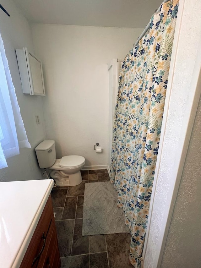 bathroom featuring vanity, toilet, baseboards, tile patterned floors, and a shower with curtain