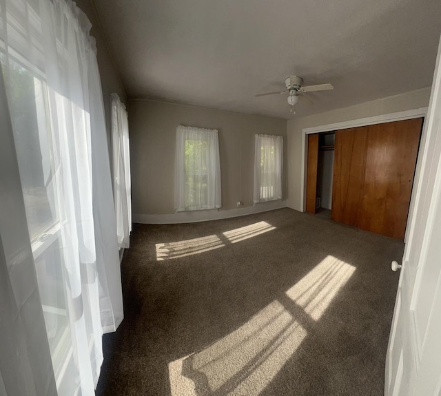 unfurnished bedroom with a ceiling fan, carpet, and a closet