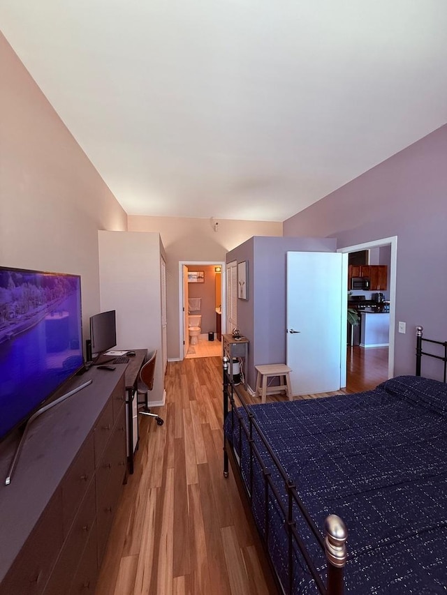 bedroom featuring light wood finished floors and baseboards