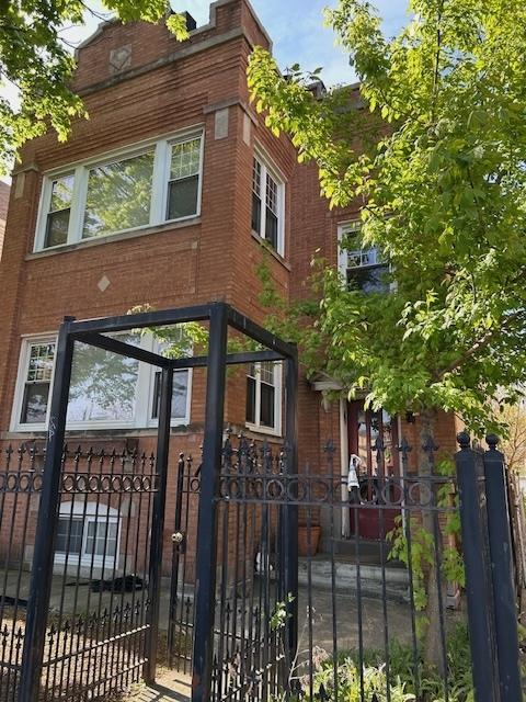3717 W Addison St, Chicago, IL 60618 - view of front facade with brick siding, a fenced front yard, and a gate