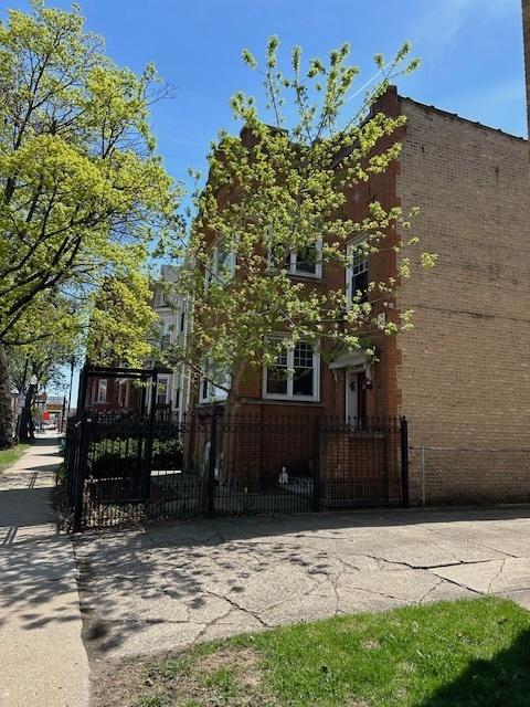 3717 W Addison St, Chicago, IL 60618 - view of side of home featuring a fenced front yard and a gate