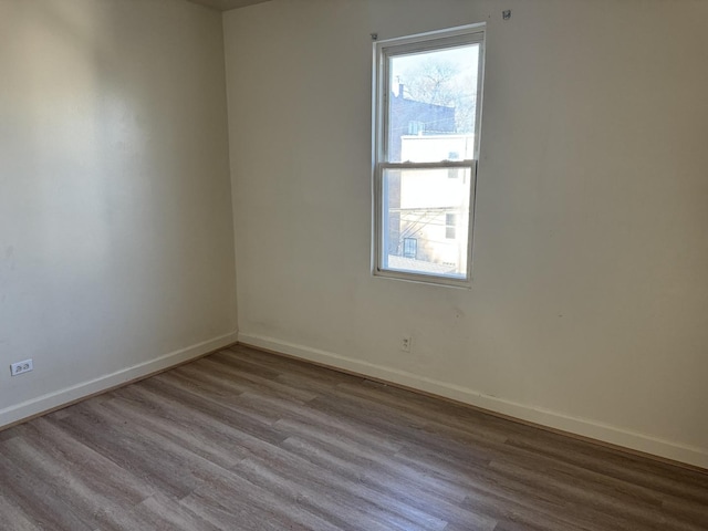 empty room with baseboards and wood finished floors