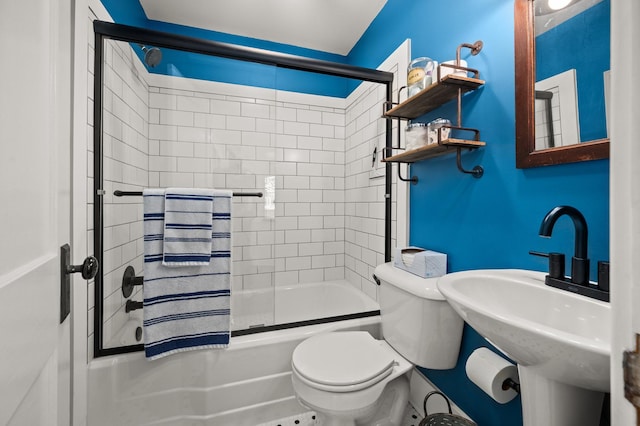 bathroom featuring a sink, enclosed tub / shower combo, and toilet