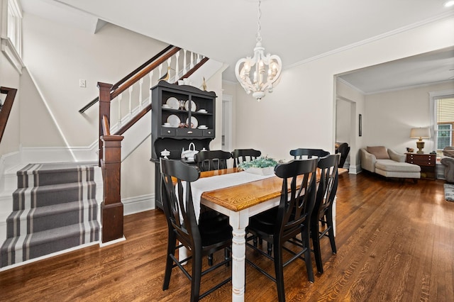 dining area with stairway, dark wood-type flooring, a chandelier, ornamental molding, and baseboards