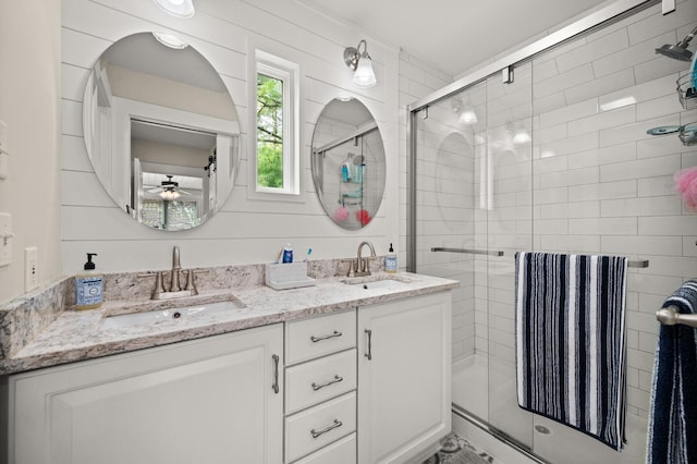 bathroom with a stall shower, a ceiling fan, and double vanity