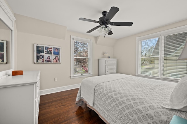 bedroom featuring baseboards, dark wood finished floors, multiple windows, and a ceiling fan