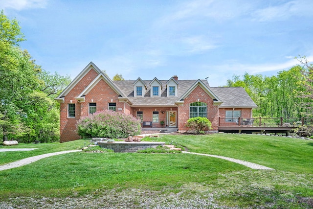 view of front of house with brick siding, a front yard, a chimney, and a shingled roof