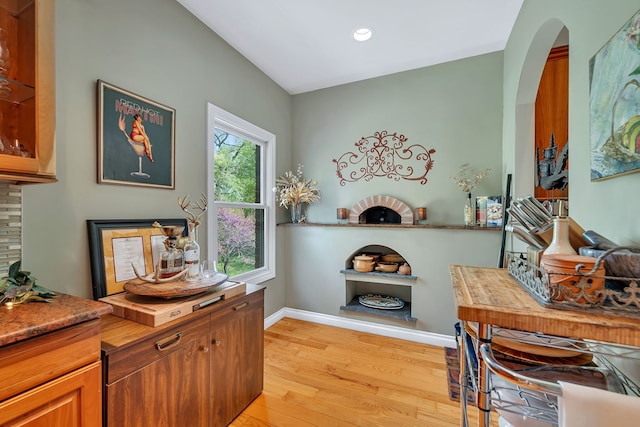 office with light wood finished floors, baseboards, arched walkways, and recessed lighting