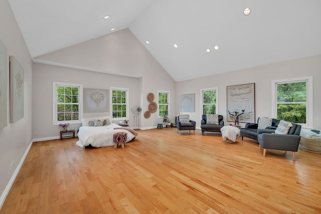 bedroom featuring high vaulted ceiling, wood finished floors, multiple windows, recessed lighting, and baseboards