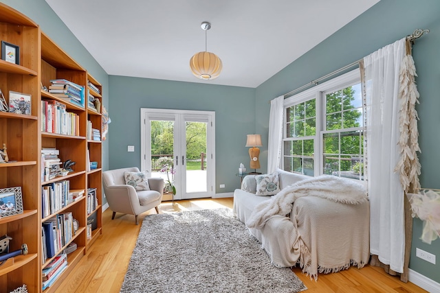 sitting room with light wood-style flooring, plenty of natural light, and baseboards