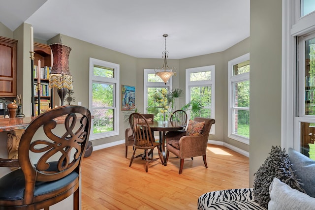dining area with baseboards and light wood finished floors